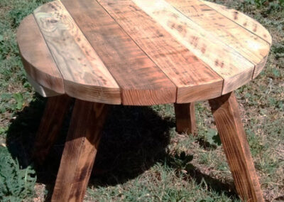 Table de salon ronde en bois de palette style industriel et pieds massifs.